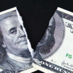 A torn hundred dollar bill featuring Benjamin Franklin