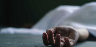Dead persons hand lying on a gray surface