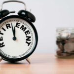 Alarm clock showing retirement and jar of coins
