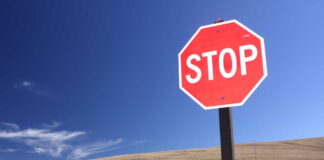 A red stop sign against a clear blue sky