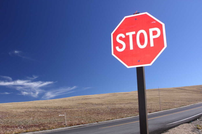 A red stop sign against a clear blue sky