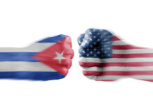 Two fists painted with Cuban and American flags.