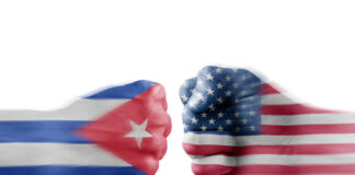 Two fists painted with Cuban and American flags.