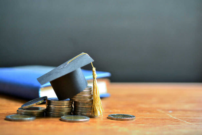 Graduation cap on top of coins to represent student loans