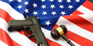 Gun and gavel on a U.S. flag.
