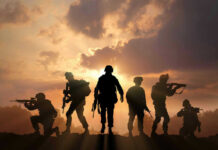 Silhouetted soldiers against a dramatic sunset sky.