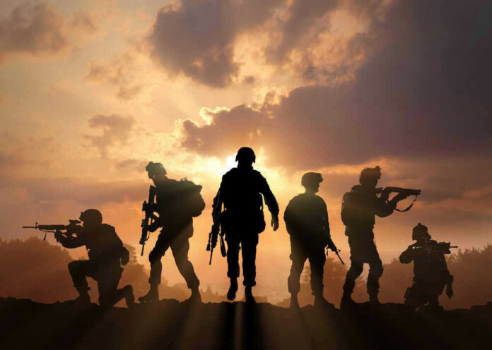 shutterstock_398557120.jpg Silhouetted soldiers against a dramatic sunset sky.