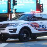 Police SUV with lights on in an urban environment