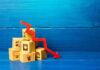 Stack of cardboard boxes with a red downward arrow indicating decline