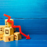 Stack of cardboard boxes with a red downward arrow indicating decline