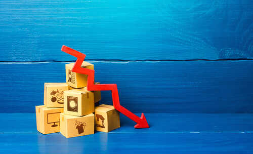 Stack of cardboard boxes with a red downward arrow indicating decline