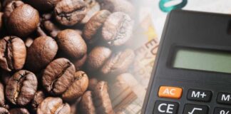 Close-up of coffee beans next to a calculator on a financial document
