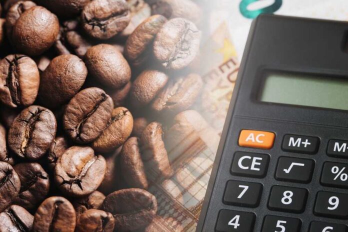 Close-up of coffee beans next to a calculator on a financial document