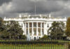 The White House with dark clouds overhead.