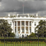 The White House with dark clouds overhead.
