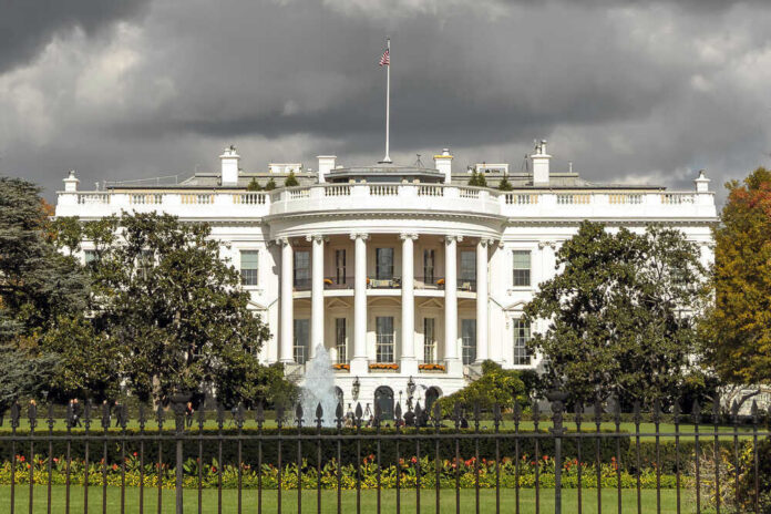 shutterstock_560339335.jpg The White House with dark clouds overhead.
