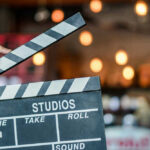 Hand holding a movie clapperboard in studio setting.