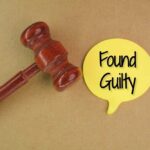 A wooden gavel next to a yellow speech bubble that says 'Found Guilty'