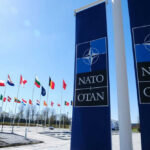 NATO flags flying under clear blue sky
