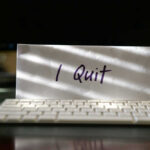 Envelope reading I Quit behind keyboard.