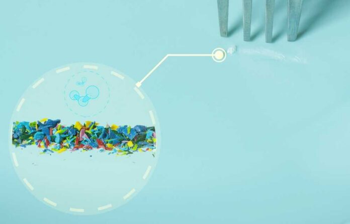 Close-up of colorful microplastic particles next to a fork on a blue surface