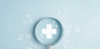 A hand holding a magnifying glass over a medical cross symbol with various health-related icons around it