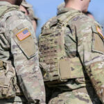 Soldiers in camouflage uniforms with American flag patches.