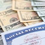 A social security card placed on top of various denominations of U.S. currency