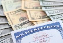 A social security card placed on top of various denominations of U.S. currency