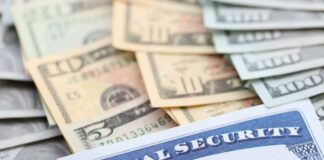 A social security card placed on top of various denominations of U.S. currency