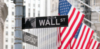 Wall Street and Broad Street signs with American flags in background