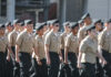 Uniformed cadets marching in formation outdoors