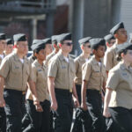 Uniformed cadets marching in formation outdoors
