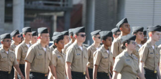 Uniformed cadets marching in formation outdoors