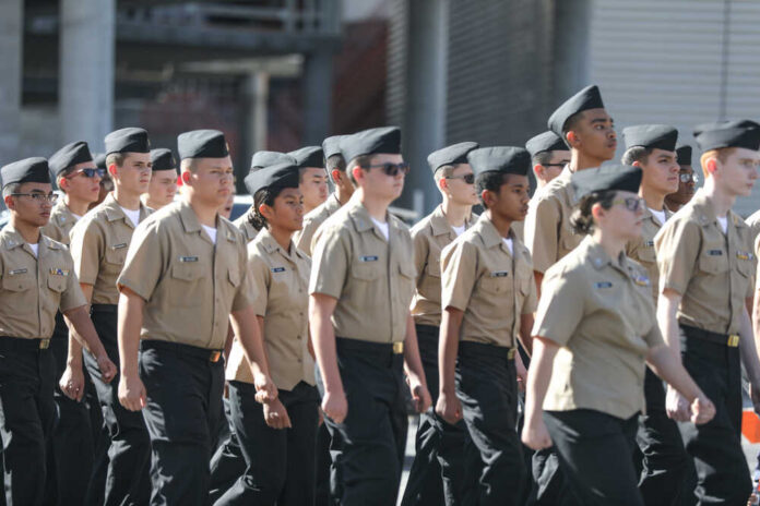 Uniformed cadets marching in formation outdoors